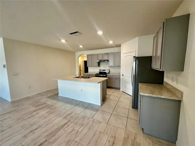 a view of a kitchen with a sink and a refrigerator