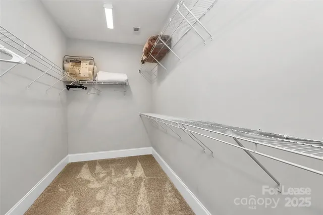 a view of walk in closet with clothes