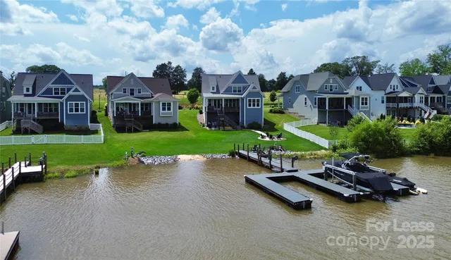 an aerial view of a house with swimming pool garden and brick wall