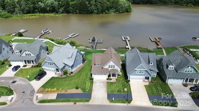 an aerial view of residential houses with outdoor space and lake view