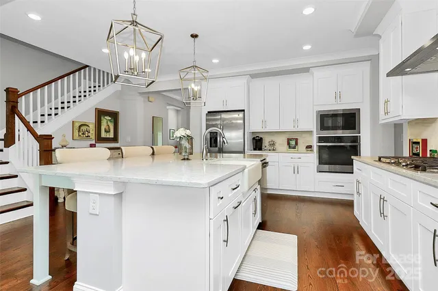 a kitchen with stainless steel appliances kitchen island granite countertop a sink and cabinets
