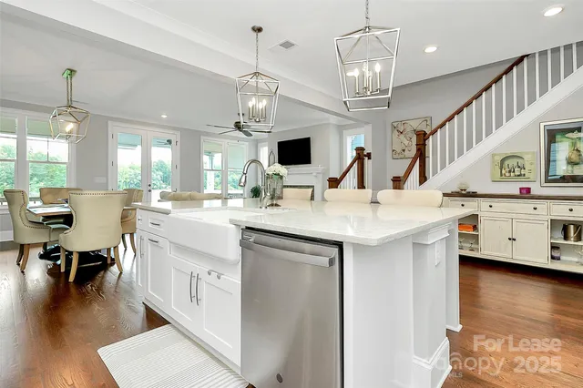 a large kitchen with stainless steel appliances kitchen island granite countertop a large island a stove a dining table and chairs with wooden floor