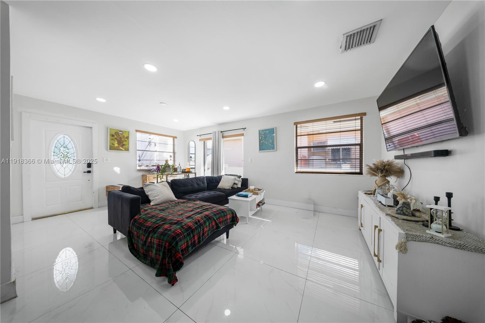 270 West 14th Street Hialeah, FL 33010 - Photo 9 of 18 a living room with furniture a window and a flat screen tv