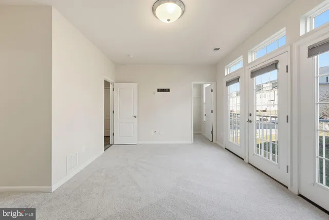 a view of a big room with windows and entryway