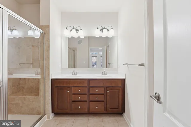 a bathroom with a granite countertop sink mirror and a shower
