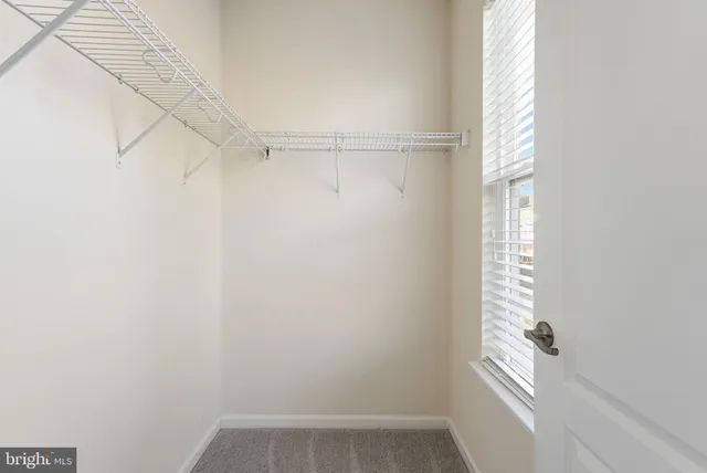 a view of small space with racks on the wall and a window