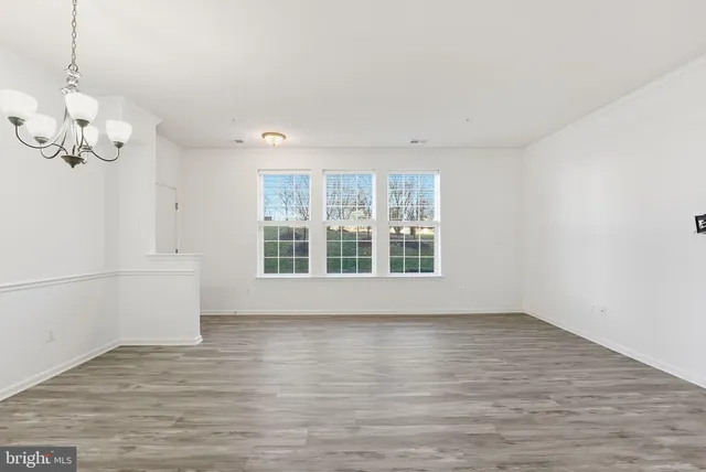 a view of wooden floor and a chandelier in a room