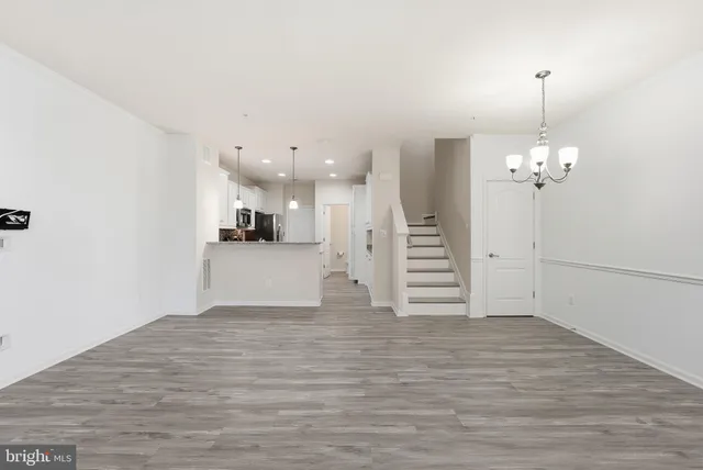 a view of a kitchen with wooden floor and a ceiling fan