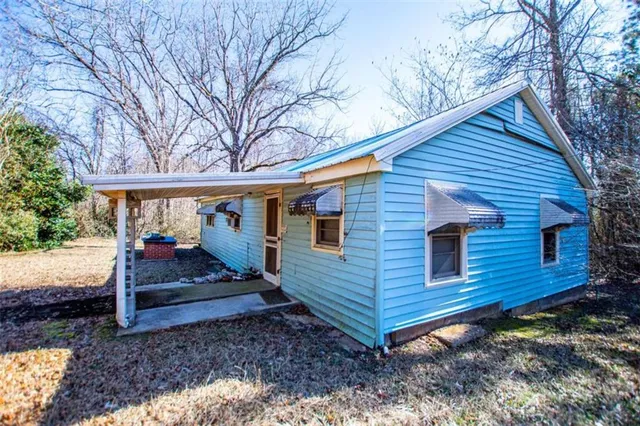 a view of a house with a yard chairs and wooden fence