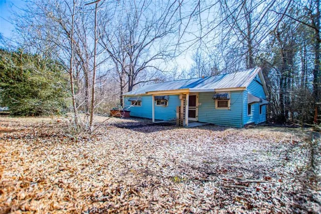 a view of a house with a yard and large tree