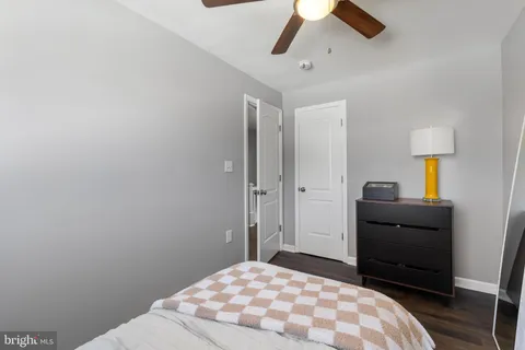 a bedroom with a bed and a lamp on the dresser