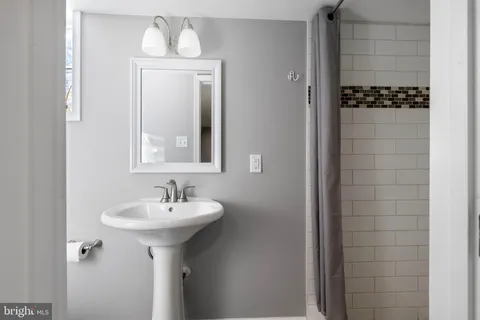 a bathroom with a sink a mirror and shower