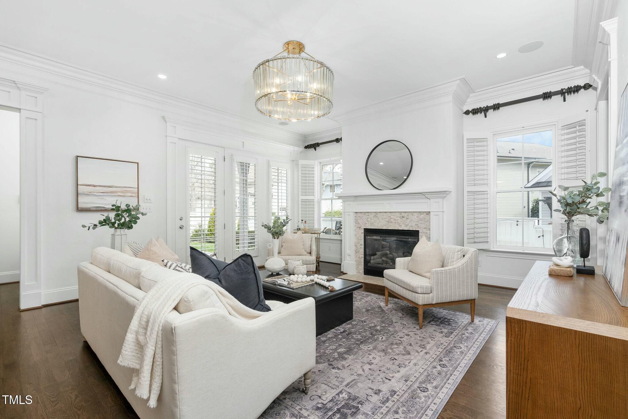 543 Guilford Circle Raleigh, NC 27608 - Photo 11 of 62 a living room with furniture a fireplace and a chandelier