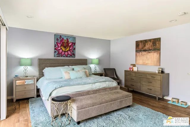 a bedroom with a bed and a lamp on dresser