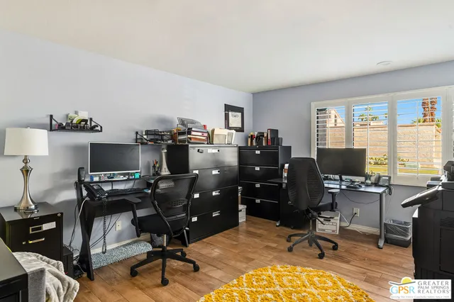 a view of a workspace with furniture and a window