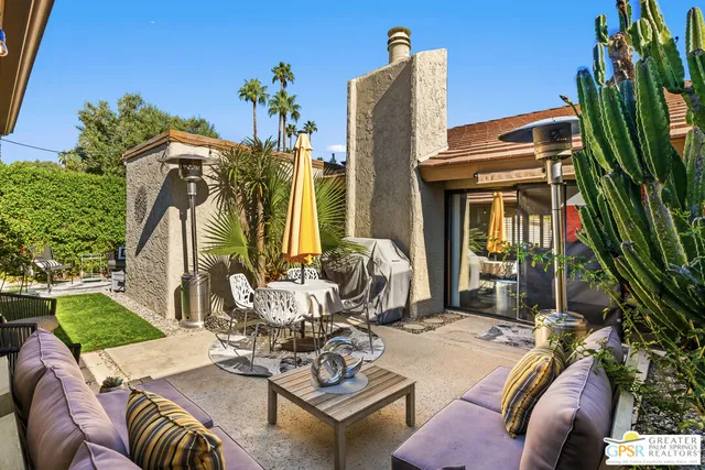 a view of a patio with couches table and chairs and potted plants