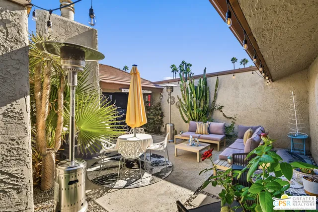 a backyard of a house with barbeque oven table and chairs
