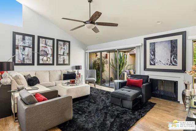 a living room with furniture a large window and a fireplace