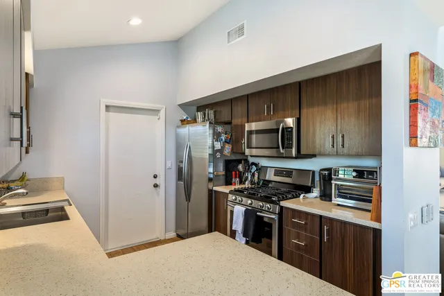 a kitchen with a refrigerator stove top oven and sink