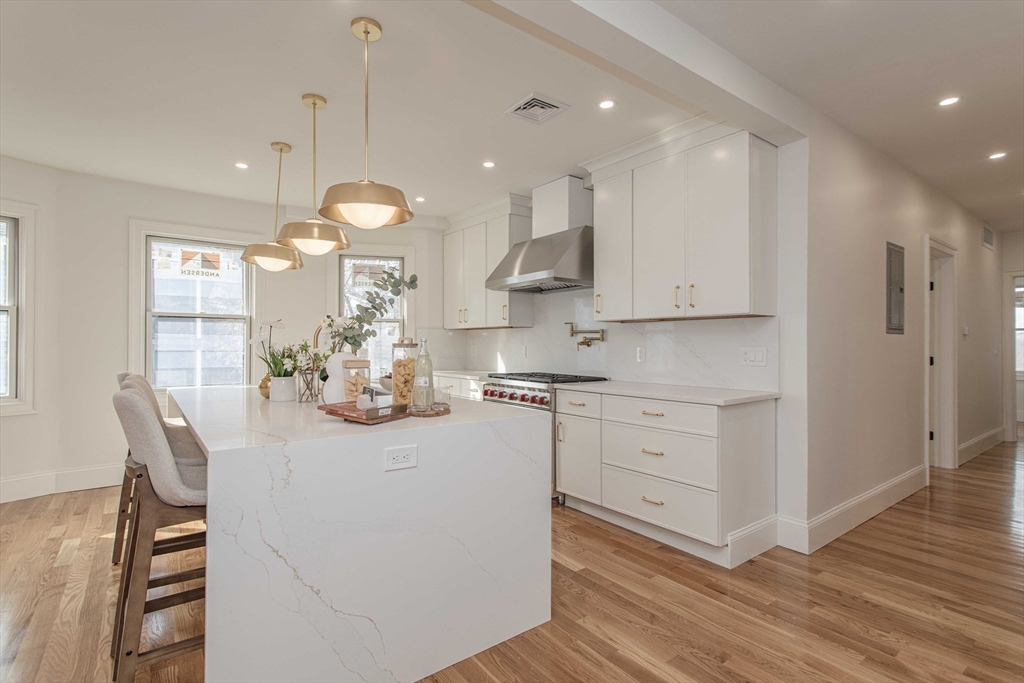 125 Mt Vernon Street, Unit 2 Newton, MA 02465 - Photo 7 of 36 a kitchen with white cabinets and sink