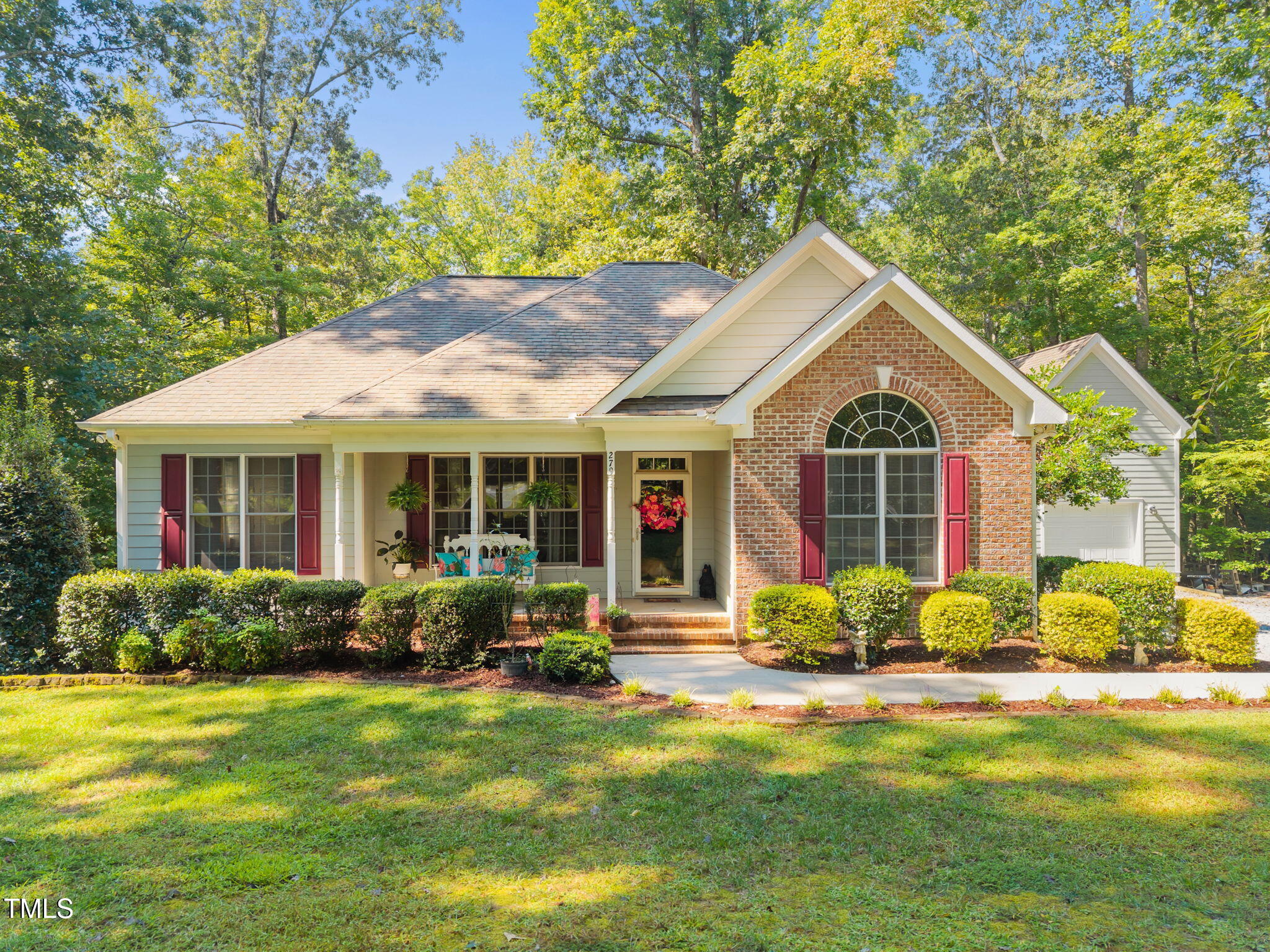 a front view of a house with porch and garden