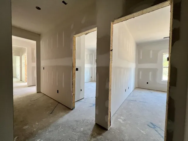 an empty room with a bathroom and mirror