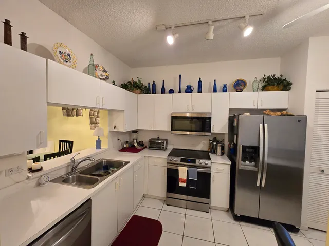 a kitchen with stainless steel appliances a refrigerator sink and microwave