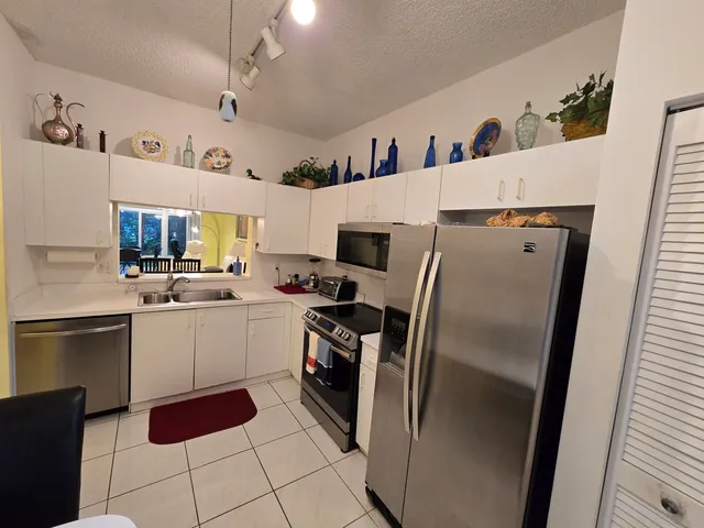 a kitchen with a refrigerator sink and cabinets