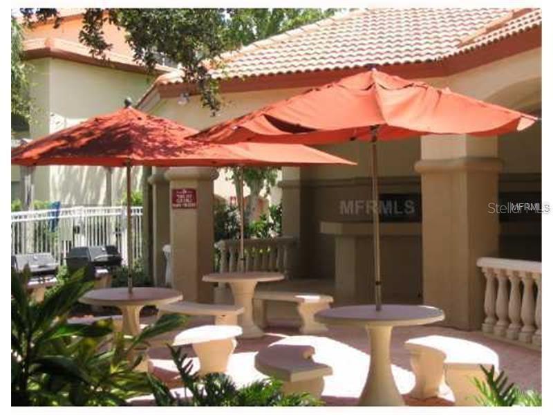 831 Camargo Way, Unit 311 Altamonte Springs, FL 32714 - Photo 26 of 28 a patio with a table and chairs under an umbrella