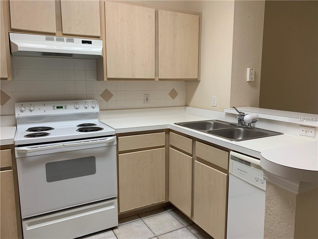 831 Camargo Way, Unit 311 Altamonte Springs, FL 32714 - Photo 6 of 28 a kitchen with cabinets and white appliances