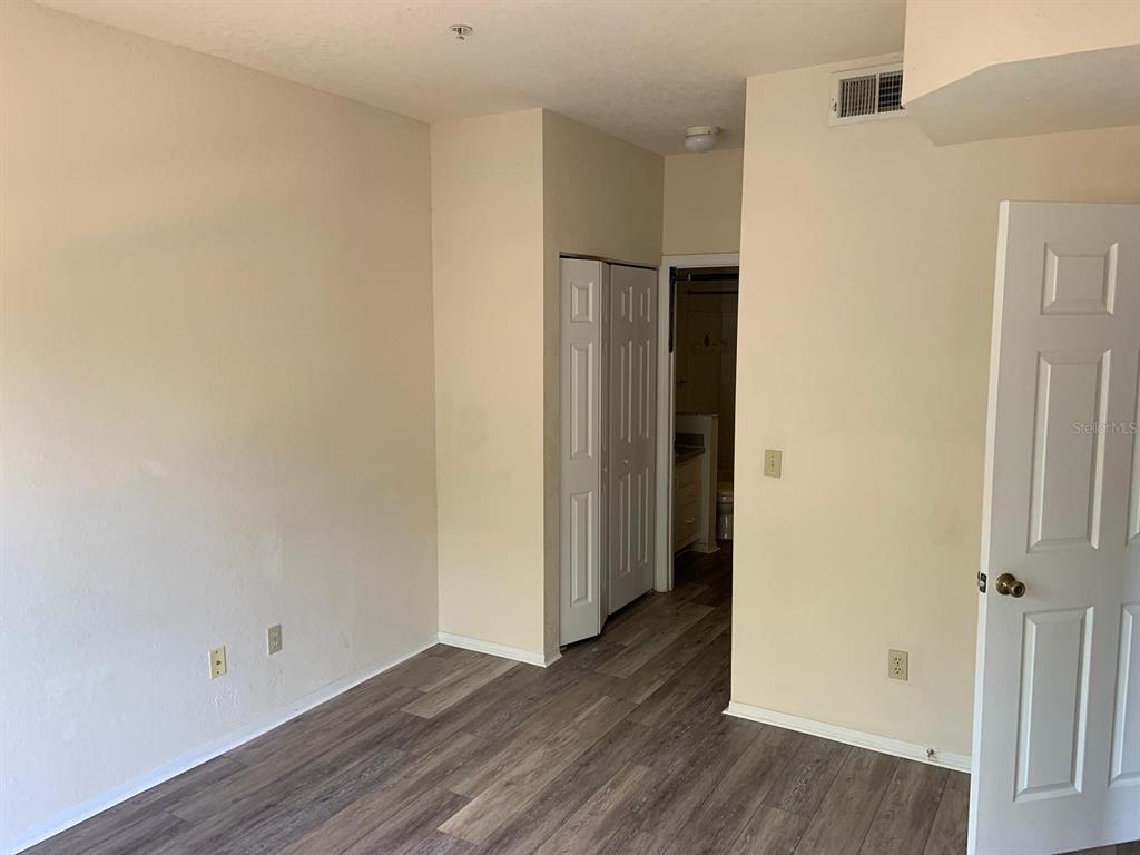 831 Camargo Way, Unit 311 Altamonte Springs, FL 32714 - Photo 7 of 28 a view of an empty room with wooden floor and closet