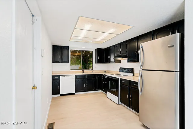 a kitchen with stainless steel appliances a refrigerator and a stove top oven