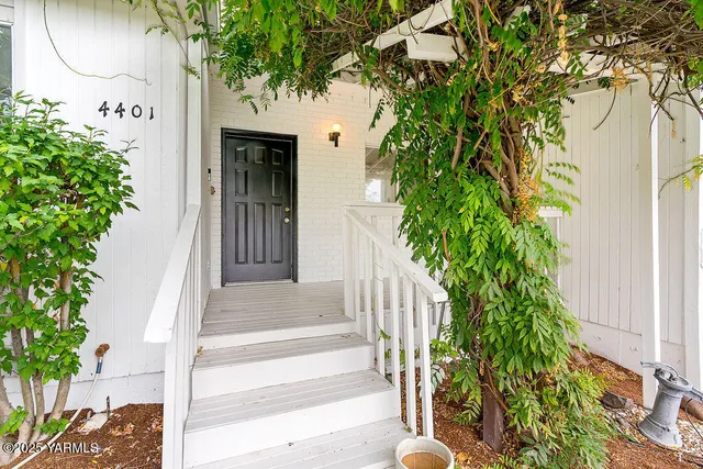 a front view of a house with a tree