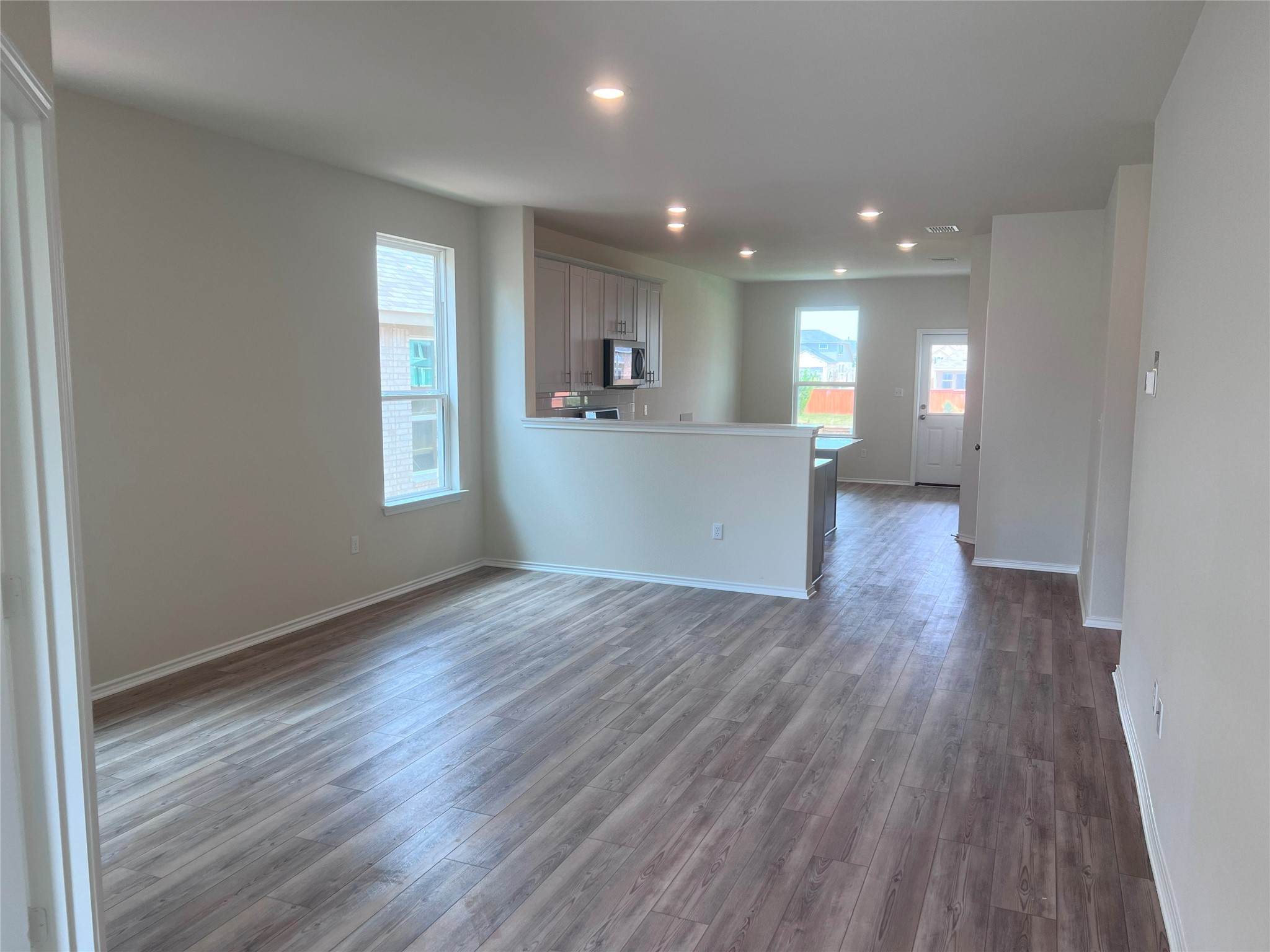 427 Tree Nut Loop Buda, TX 78610 - Photo 7 of 38 a view of a big room with wooden floor and windows