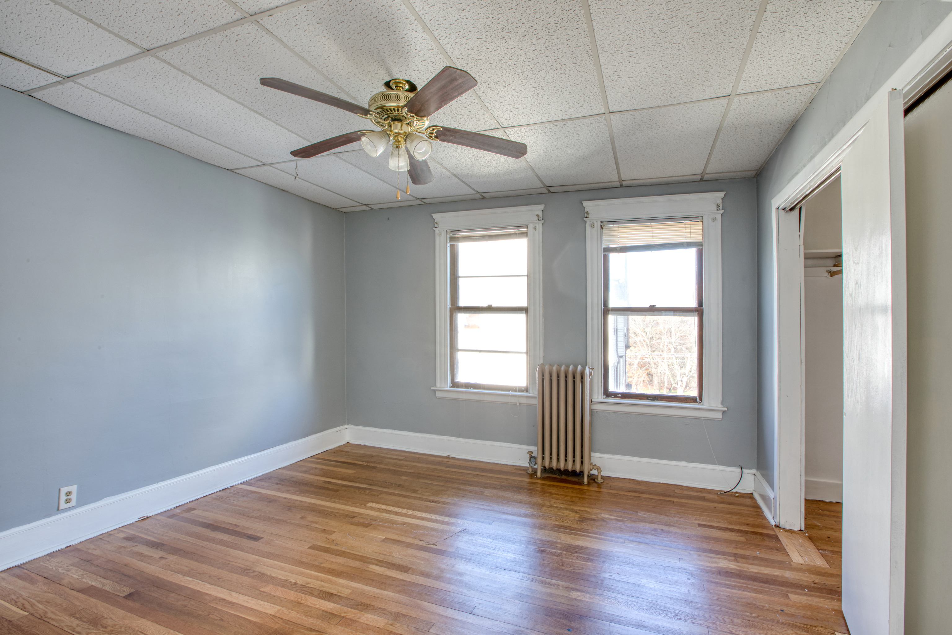 226 Ledgeside Avenue, Unit 228 Waterbury, CT 06708 - Photo 13 of 19 an empty room with wooden floor fan and windows