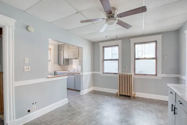a large white kitchen with granite countertop a sink and dishwasher with white cabinets