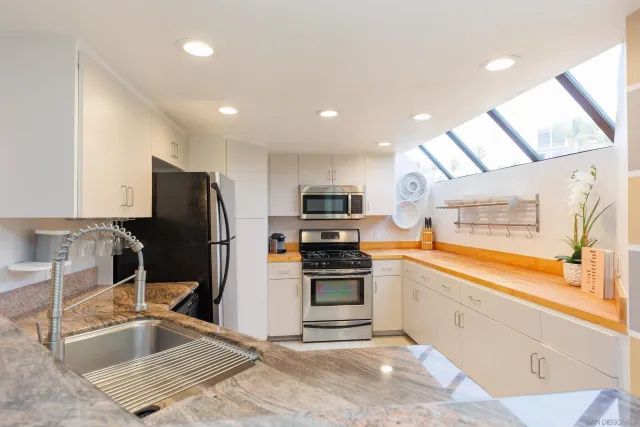 a kitchen with stainless steel appliances granite countertop a refrigerator and a sink