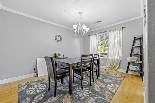 a view of a dining room with furniture and a chandelier