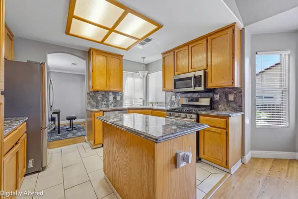 a kitchen with stainless steel appliances granite countertop sink stove top oven and cabinets