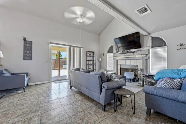 a living room with furniture a fireplace and a flat screen tv
