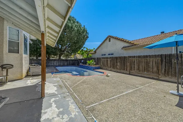 a view of a backyard with brick wall and potted plants