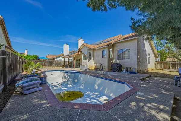a view of a house with backyard and sitting area