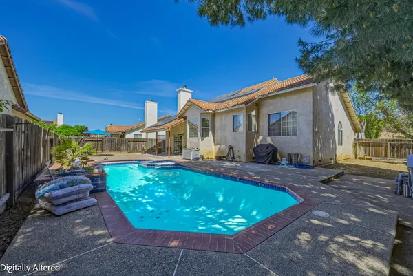 a view of a swimming pool with back yard of a house