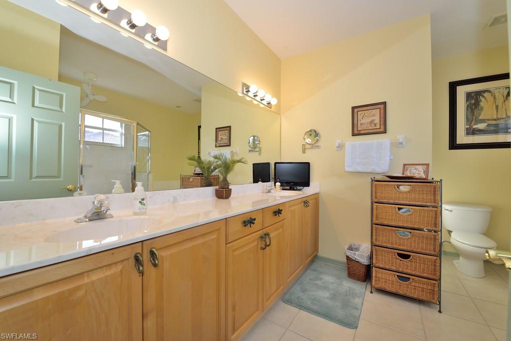 8125 Celeste Drive, Unit 5216 Naples, FL 34113 - Photo 8 of 11 a bathroom with a sink vanity and mirror