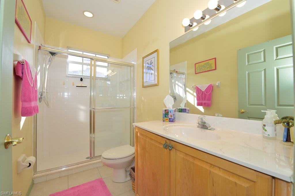8125 Celeste Drive, Unit 5216 Naples, FL 34113 - Photo 10 of 11 a bathroom with a sink vanity mirror and shower