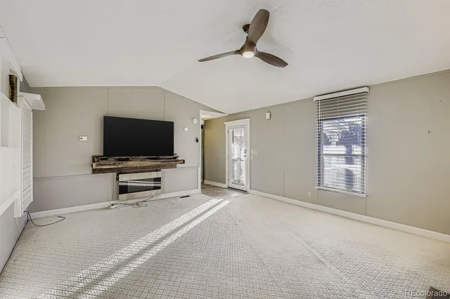 a living room with flat screen tv and a window