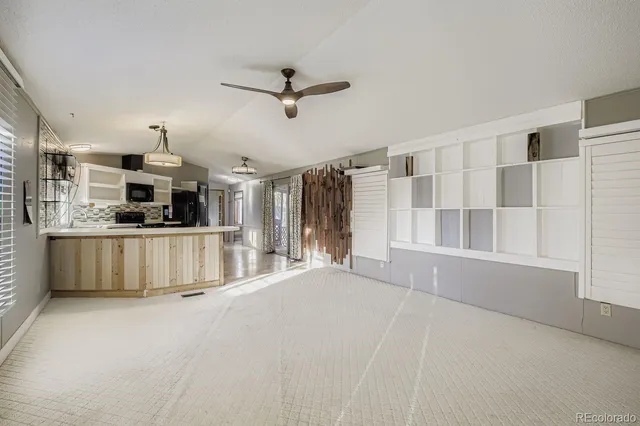 a view of a kitchen with kitchen island stainless steel appliances wooden floor and window