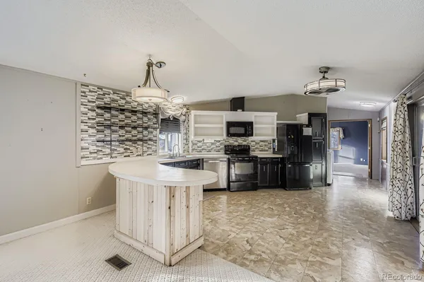 a kitchen with stainless steel appliances kitchen island granite countertop a sink and cabinets