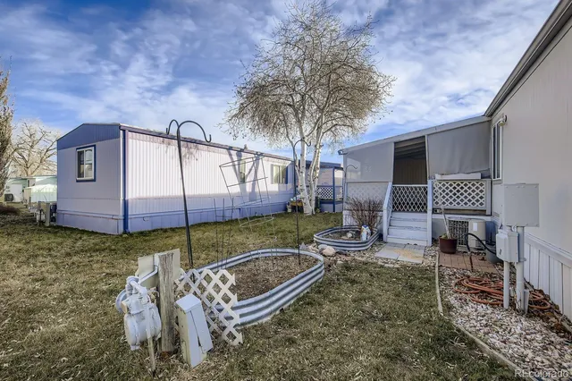 a backyard of a house with barbeque oven table and chairs