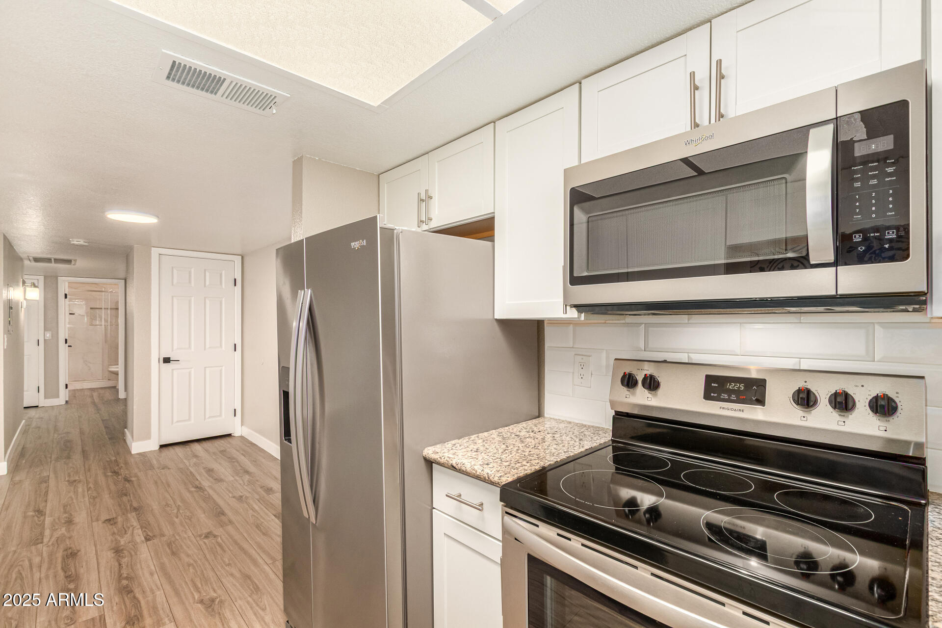 2633 West Ocotillo Road, Unit 3 Phoenix, AZ 85017 - Photo 12 of 27 a kitchen with stainless steel appliances and wooden cabinets